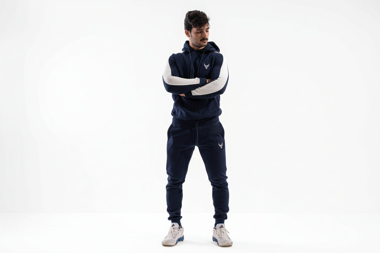 Man wearing a navy tracksuit with white sleeves on a white background

