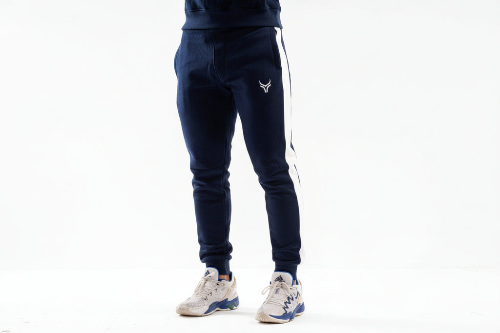 Navy blue jogger pants with a logo on a white background

