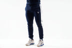 Navy blue jogger pants with a logo on a white background

