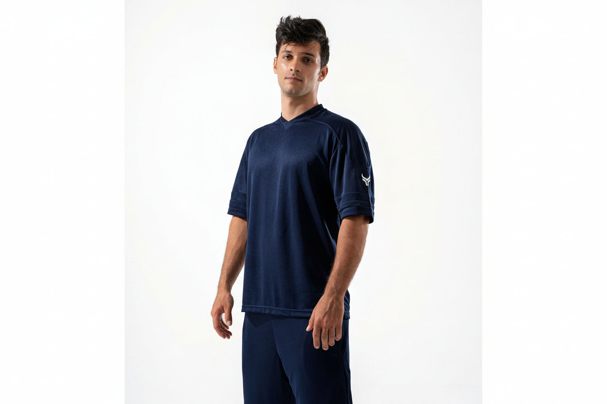 Man wearing a navy blue athletic outfit with a logo on a white background