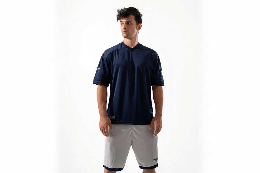 Man wearing a navy-blue shirt and white shorts on a white background

