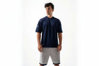 Man wearing a navy-blue shirt and white shorts on a white background

