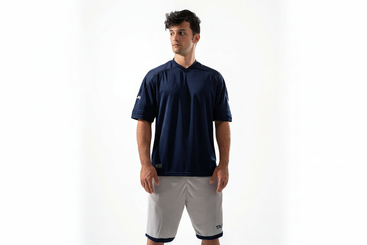 Man wearing a navy-blue shirt and white shorts on a white background

