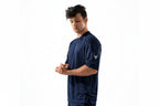 Man wearing a navy blue sports outfit with a logo on a white background