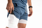 Person wearing blue and white athletic shorts on a white background

