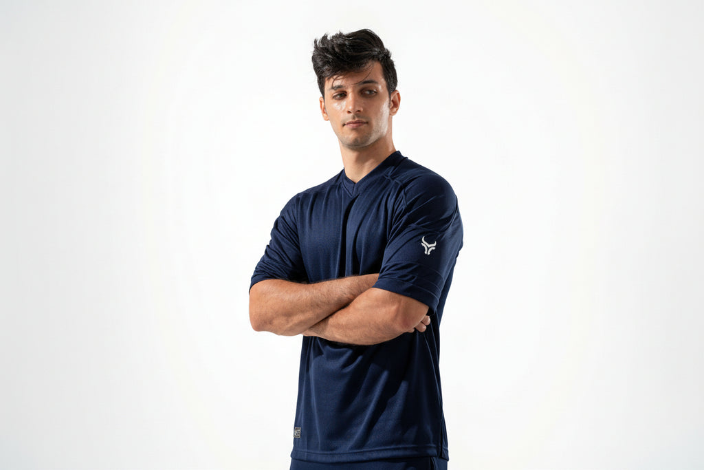 Man wearing a navy blue athletic outfit with a logo on a white background
