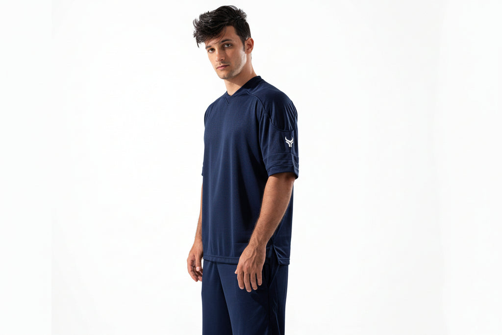 Man wearing navy athletic outfit with logo on a white background