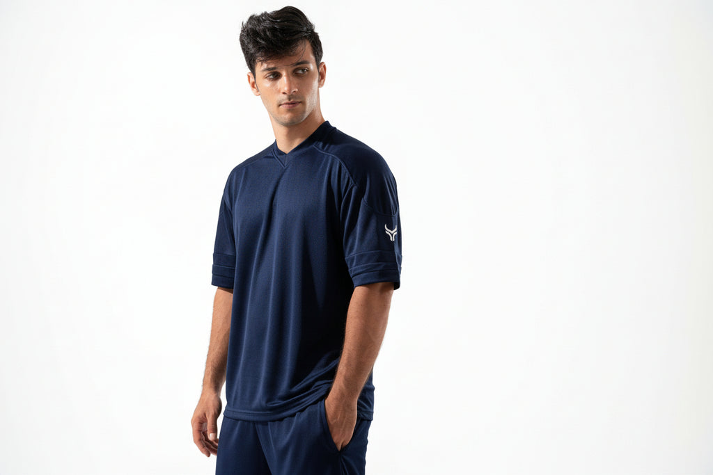 Man wearing a navy blue athletic outfit with a logo on a white background
