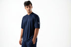 Man wearing a navy blue athletic outfit with a logo on a white background