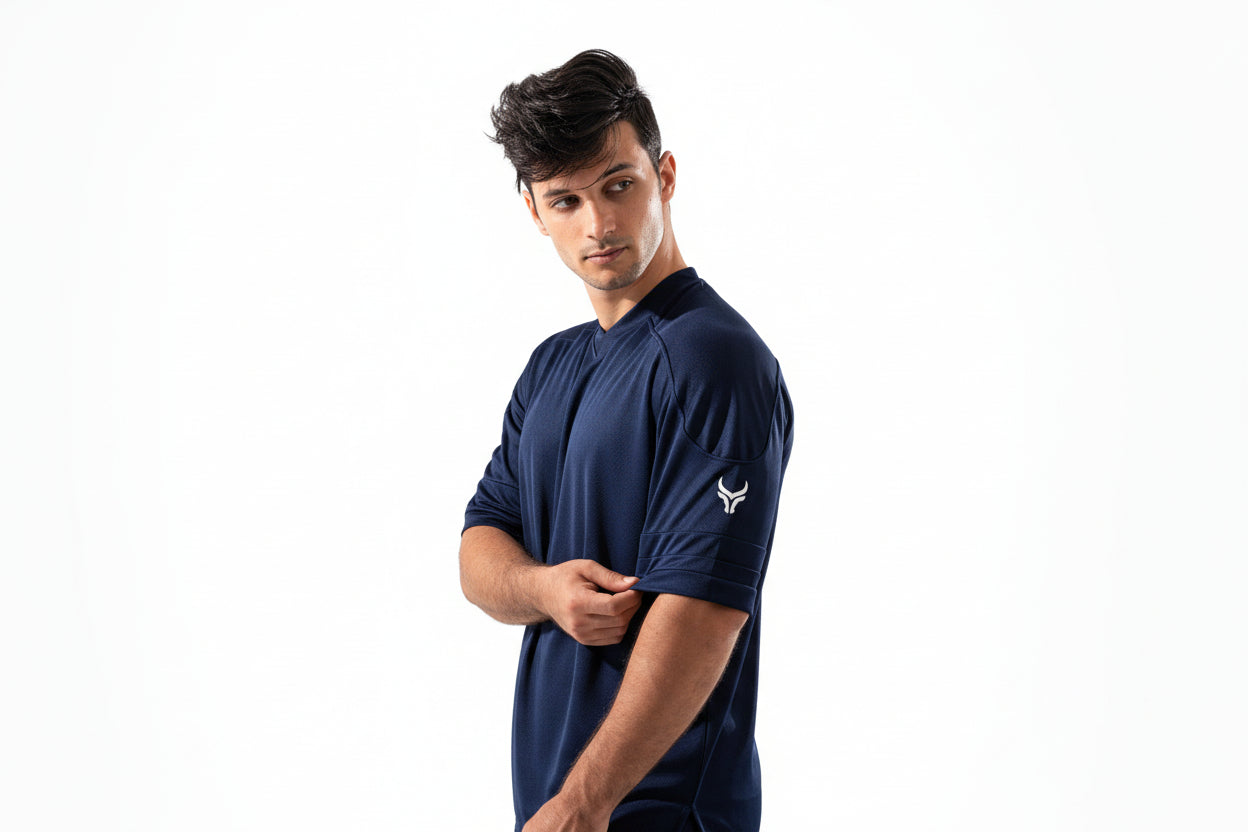Man wearing a navy blue athletic outfit with a logo on a white background