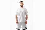 Man wearing a white t-shirt and shorts with a brand logo on a white background

