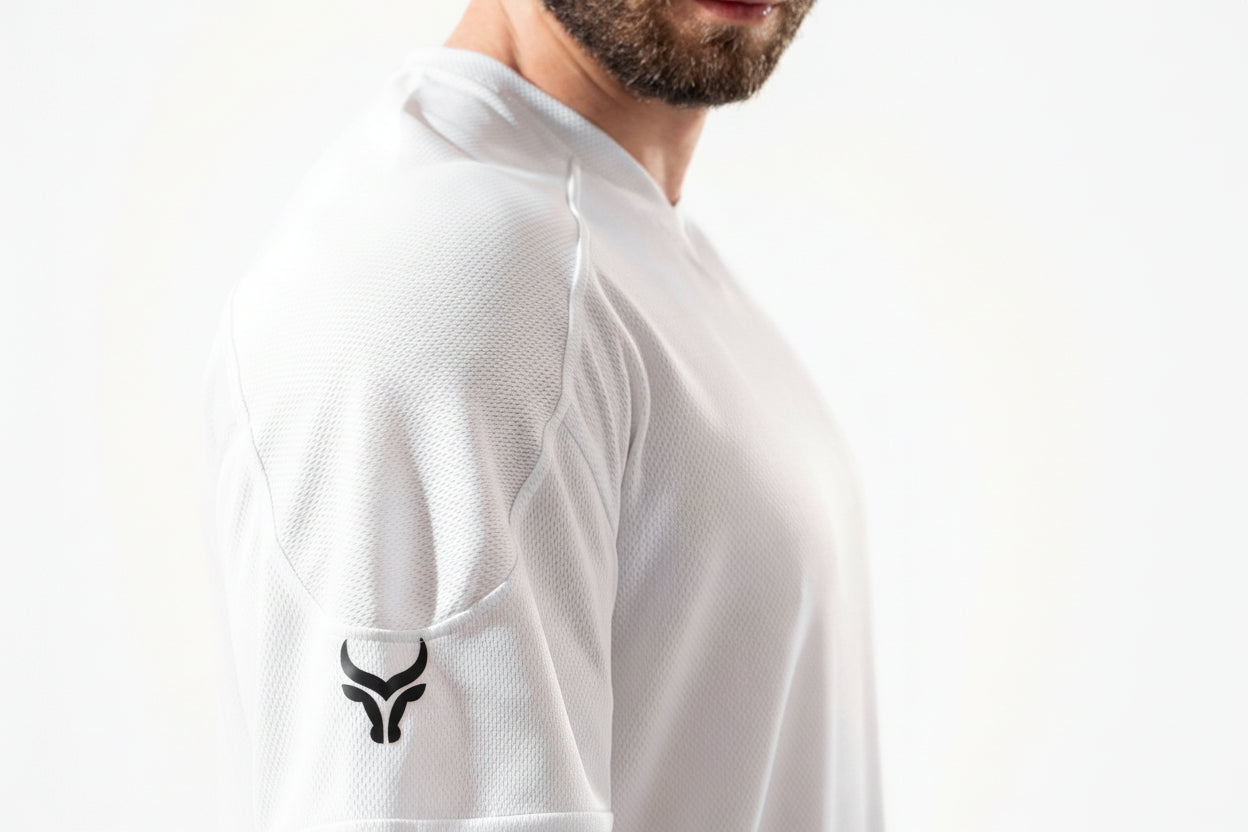 White athletic shirt with a logo on the sleeve against a white background

