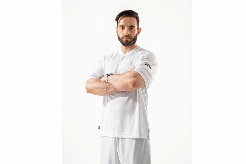 Man wearing a white sports outfit with visible branding on a white background