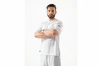 Man wearing a white sports outfit with visible branding on a white background
