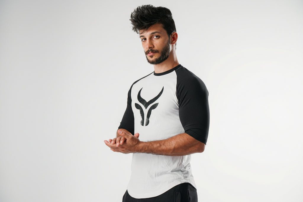 Man wearing a black and white athletic outfit with a logo on a white background
