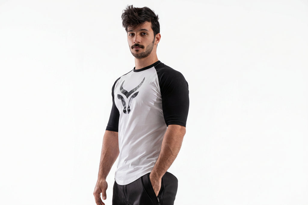 Man wearing a white and black baseball shirt with a logo on a white background

