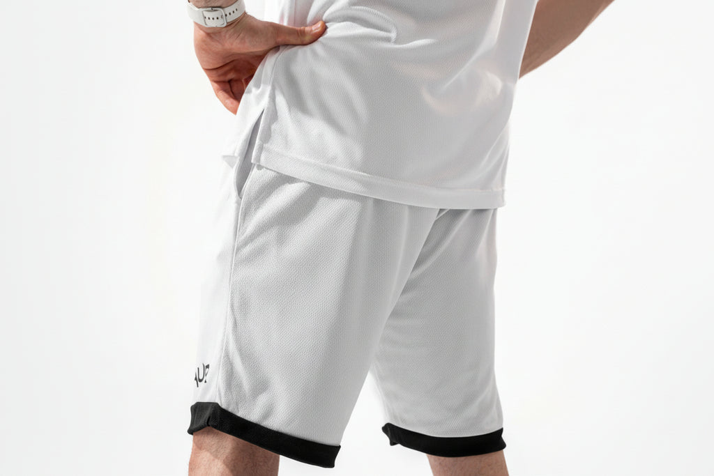 White athletic shorts with black trim on a white background