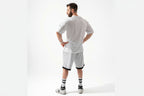 Man wearing a white sports outfit with black accents on a white background
