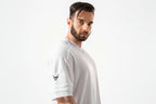 Man wearing a white t-shirt with a logo on a white background

