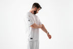 Man wearing a white sports outfit with a logo on a white background