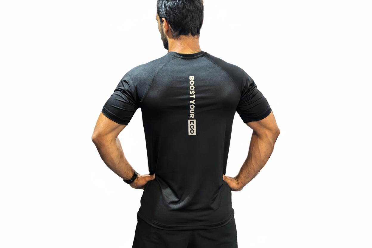 Person wearing a black athletic shirt with 'Boost Your Ego' text on the back, standing in a gym.